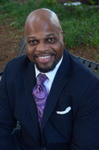 A man in a suit and tie sitting on top of a bench.